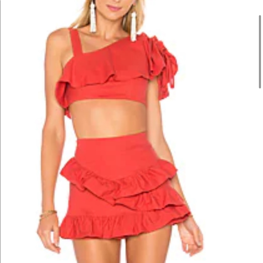 Coral/red, ruffled, asymmetrical, top with matching skort set by Tularosa.